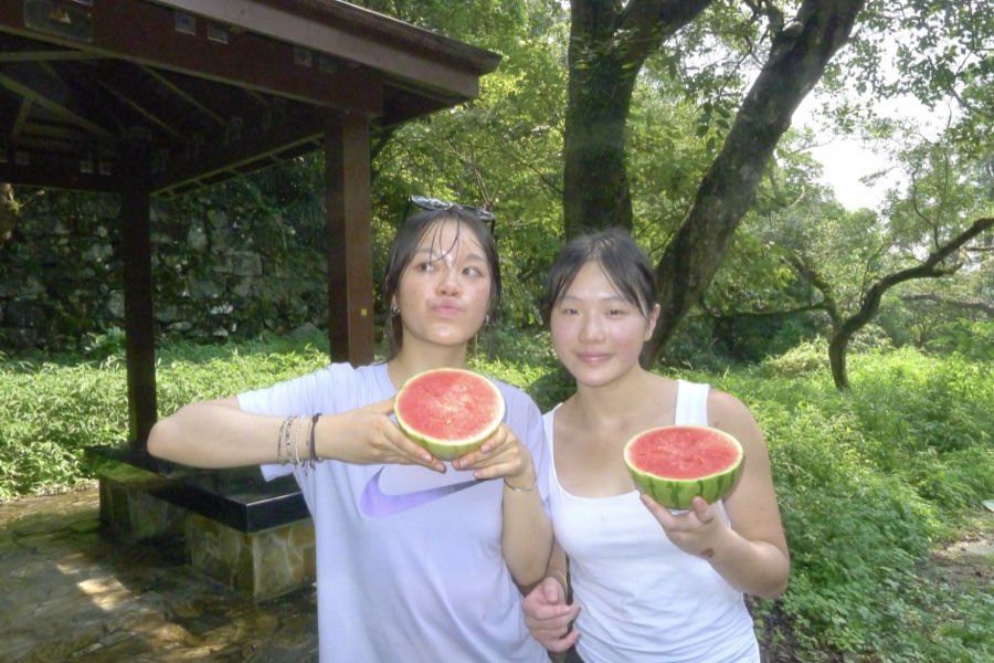 Friends eating watermelon with a spoon at the peak of Ma On Shan, Hong Kong